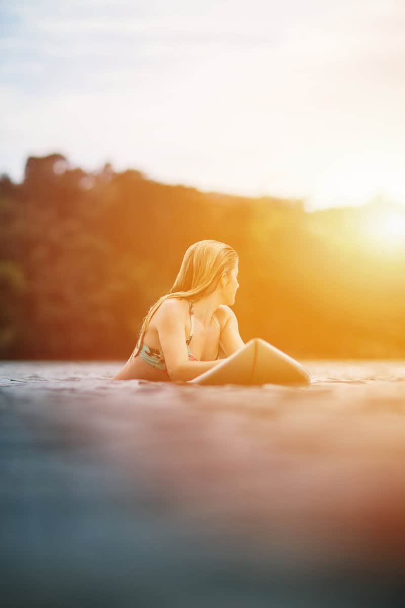 woman in yellow bikini lying on beach during sunset