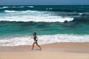 woman in blue bikini walking on beach during daytime