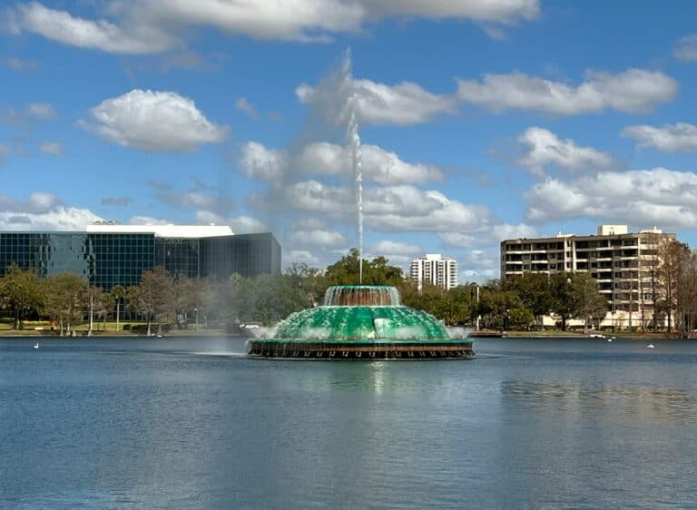 a large green fountain in the middle of a lake