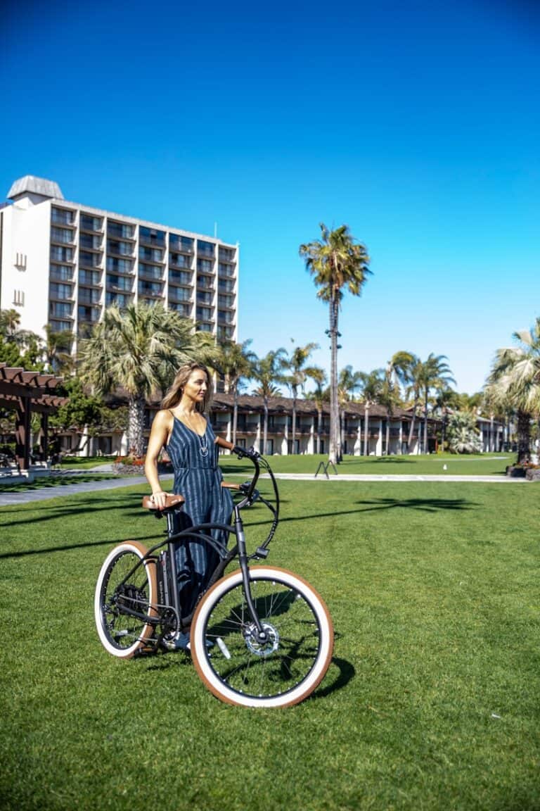 woman standing near bicycle on grass field